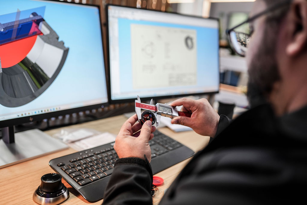 Technische Entwicklung mit CAD-Konstruktion und Präzisionsmessung eines Bauteils im Maschinenbau